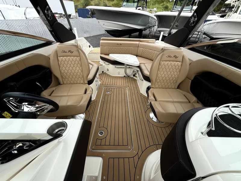 Slide: The Image of 2019 Sea Ray SLX 250 boat interior with tan leather seating and wood-style flooring. - 15