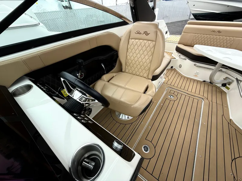 Slide: The Image of 2019 Sea Ray SLX 250 boat interior with tan leather seating and wood-style flooring. - 16