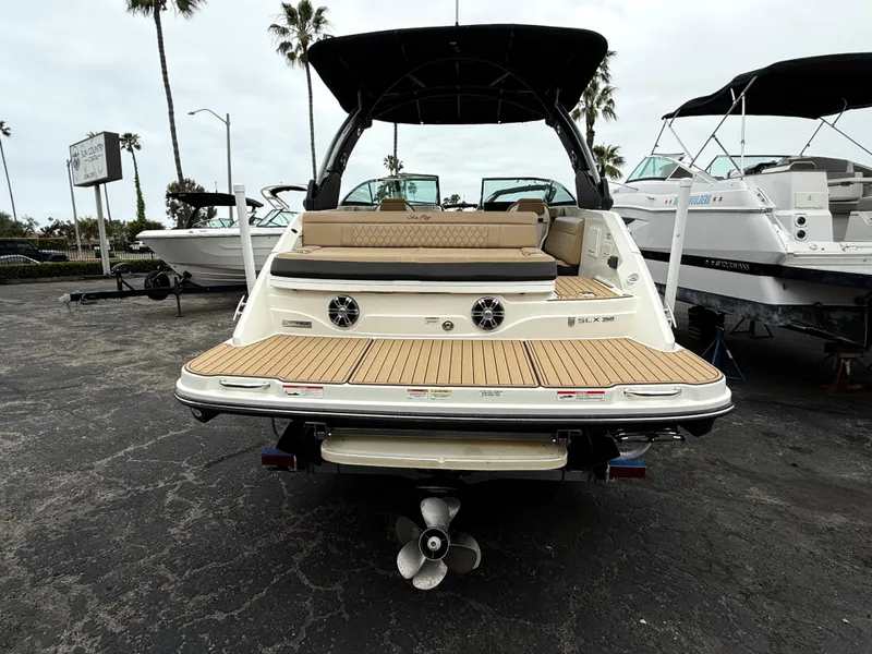 Slide: The Image of 2019 Sea Ray SLX 250 boat with teak swim platform and seating, docked outdoors. - 6