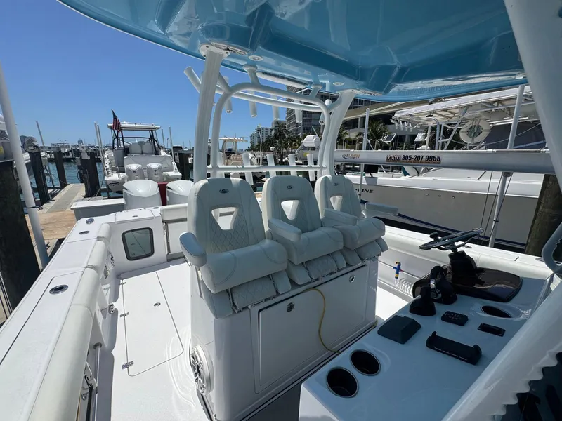 Slide: The Image of 2020 Sportsman Open 352 Center Console boat with seating and controls at a marina. - 4
