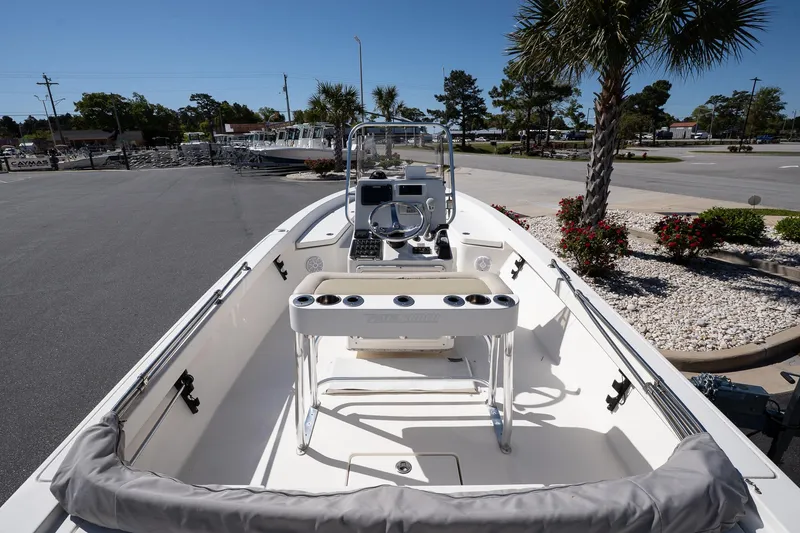 Slide: The Image of 2013 Pathfinder 2400 TRS boat interior with console and seating, parked outdoors. - 10