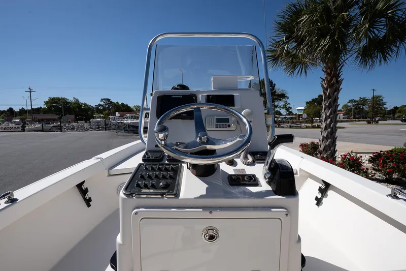 Slide: The Image of 2013 Pathfinder 2400 TRS boat console with steering wheel and controls, outdoors. - 11