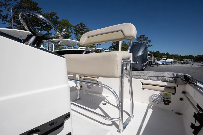 Slide: The Image of 2013 Pathfinder 2400 TRS boat interior with seating and steering wheel, under clear blue sky. - 14