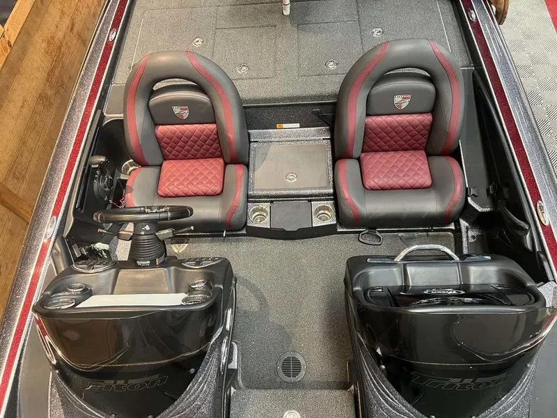 Slide: The Image of 2019 Triton 21 TrX boat interior with dual red and black seats, steering console, and storage compartments. - 4