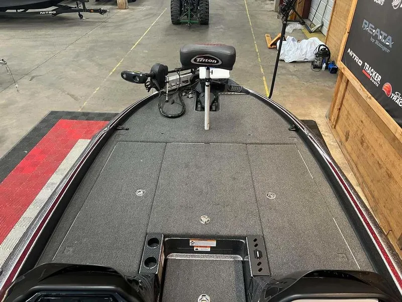 Slide: The Image of 2019 Triton 21 TrX boat deck with trolling motor in a showroom. - 6
