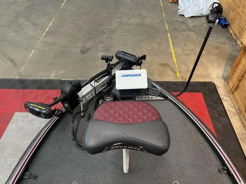Slide: The Image of 2019 Triton 21 TrX boat with Lowrance electronics and maroon seat on a trailer. - 7