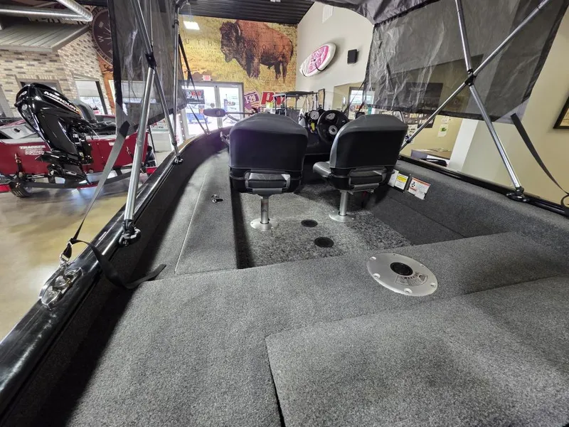 Slide: The Image of 2024 Tracker Super Guide V-16 SC boat interior with seating and carpeted deck. - 3