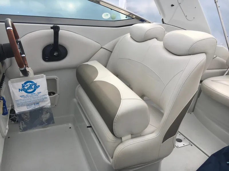 Slide: The Image of 2018 Crownline 264 CR boat interior with white leather seating and wooden steering wheel. - 10