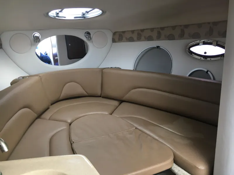 Slide: The Image of Interior of 2018 Crownline 264 CR boat with beige leather seating and porthole windows. - 20