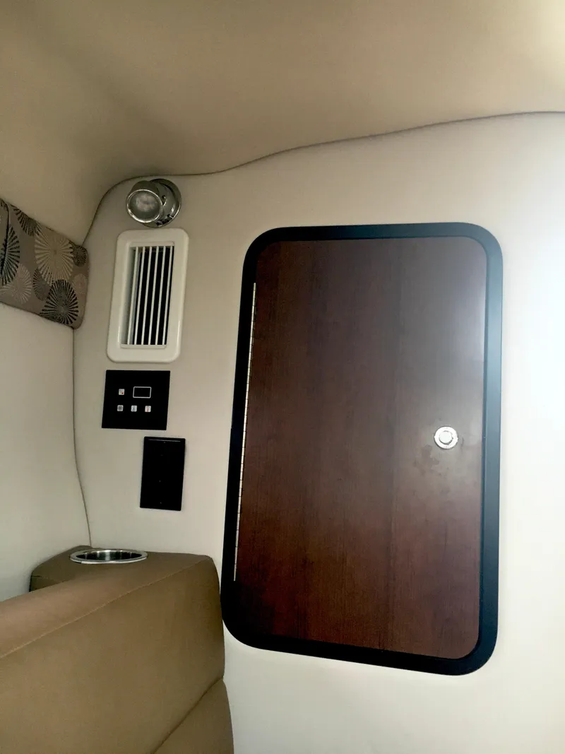 Slide: The Image of Interior view of 2018 Crownline 264 CR boat cabin with wooden door and ventilation. - 22