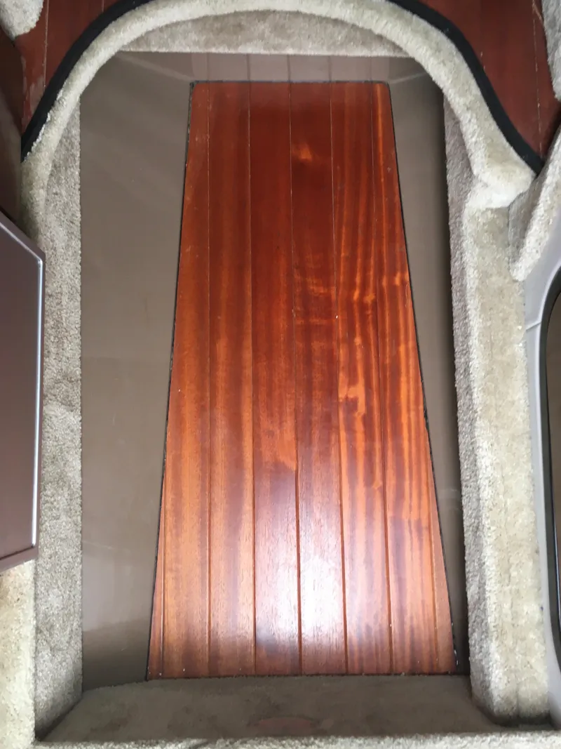 Slide: The Image of 2018 Crownline 264 CR boat interior with wooden flooring and carpeted sides. - 24