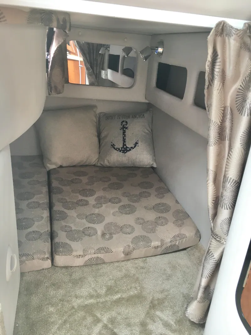 Slide: The Image of 2018 Crownline 264 CR cabin interior with anchor-themed decor and patterned cushions. - 25