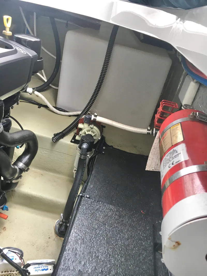 Slide: The Image of Engine compartment of a 2018 Crownline 264 CR boat with fire extinguisher and hoses. - 29