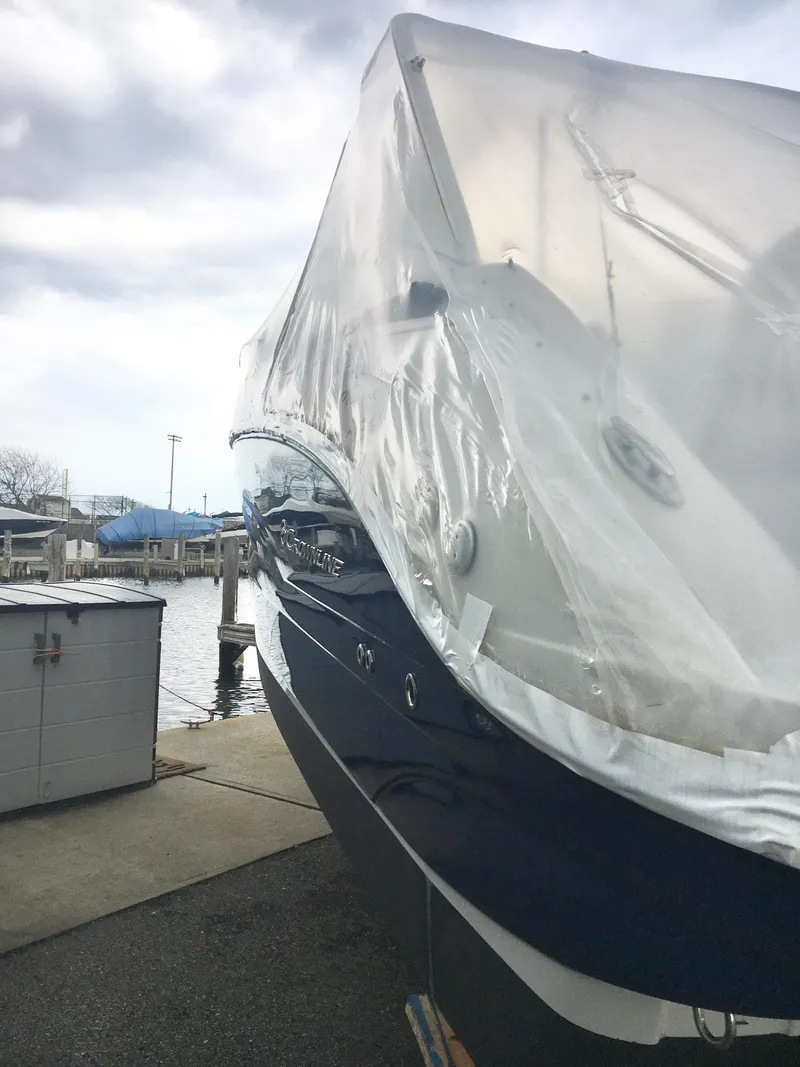 Slide: The Image of 2018 Crownline 264 CR boat covered in protective wrap at a marina. - 3
