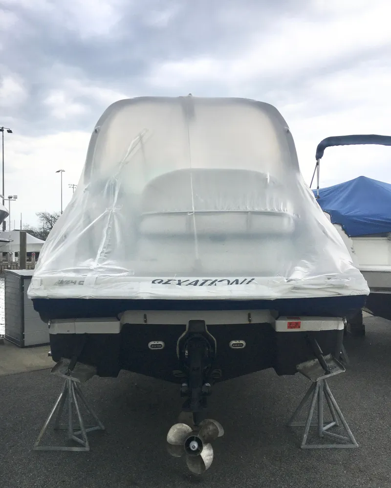Slide: The Image of 2018 Crownline 264 CR boat covered in protective wrap, displayed on stands. - 4