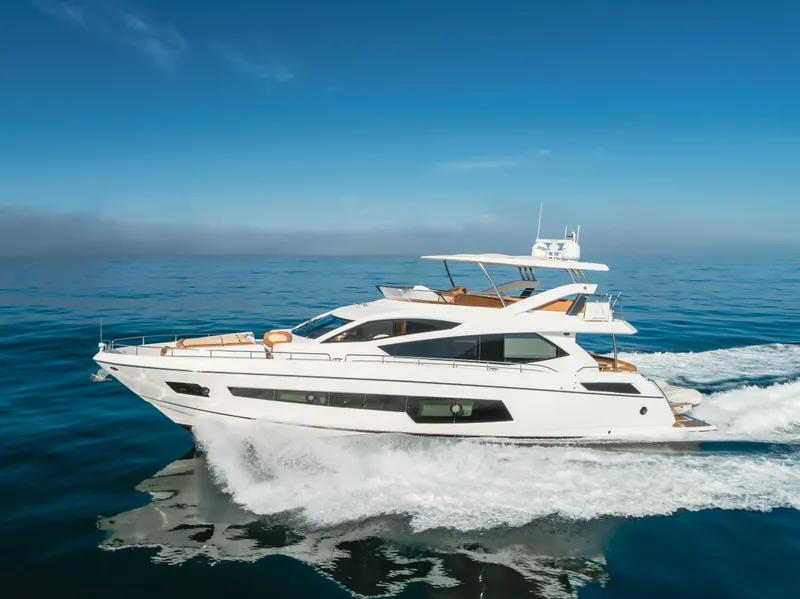 Slide: The Image of 2017 Sunseeker 75 Yacht cruising on open water under clear blue skies. - 0