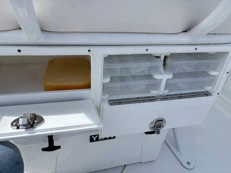 Slide: The Image of Storage compartments on a 2022 Sea Hunt Ultra 219 boat, featuring organized tackle boxes. - 12