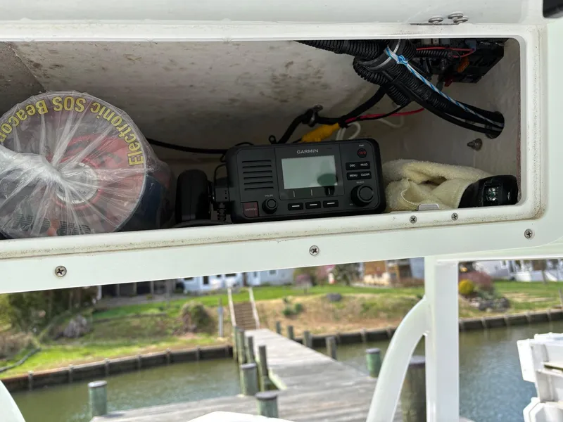 Slide: The Image of 2022 Sea Hunt Ultra 219 boat with Garmin radio and emergency supplies in storage compartment. - 13