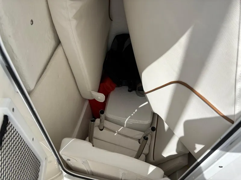 Slide: The Image of Interior view of a 2022 Sea Hunt Ultra 219 boat with white seating and storage. - 23
