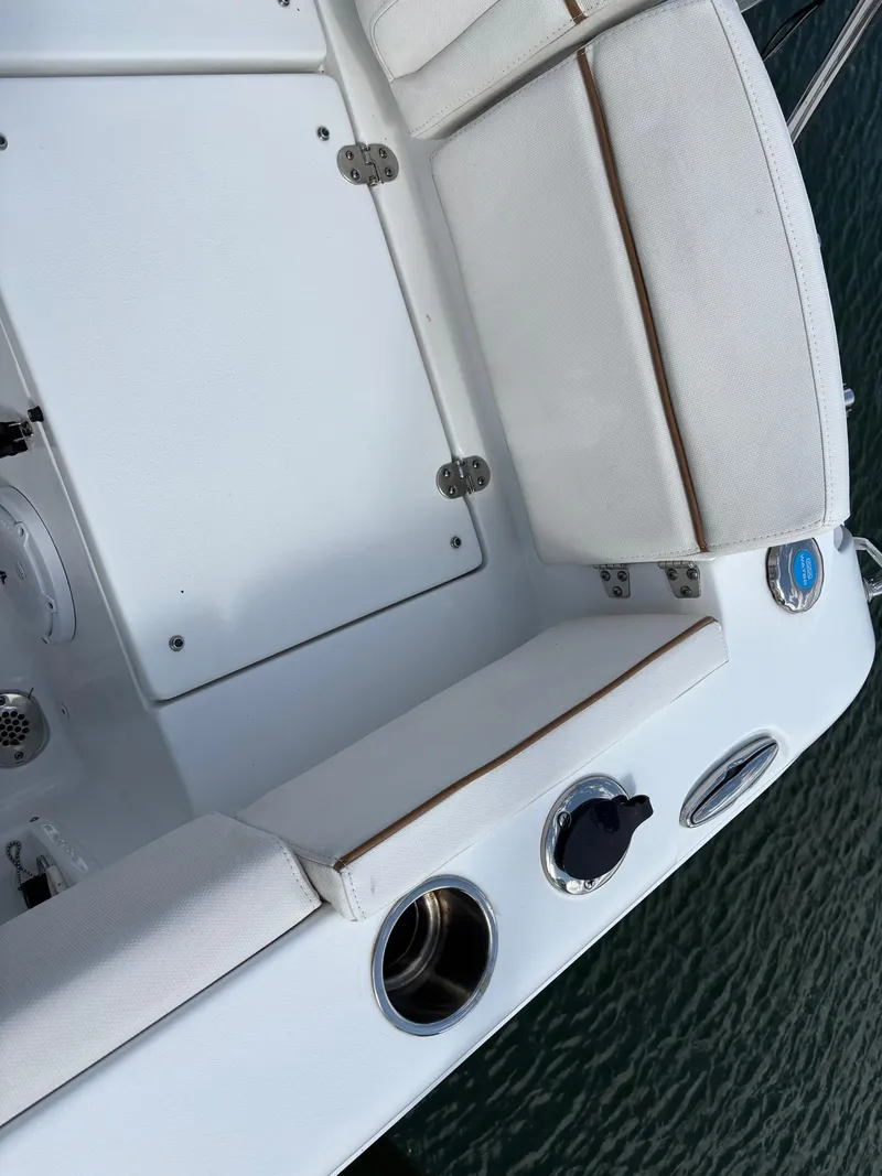 Slide: The Image of 2022 Sea Hunt Ultra 219 boat interior with white seating and cup holders. - 25