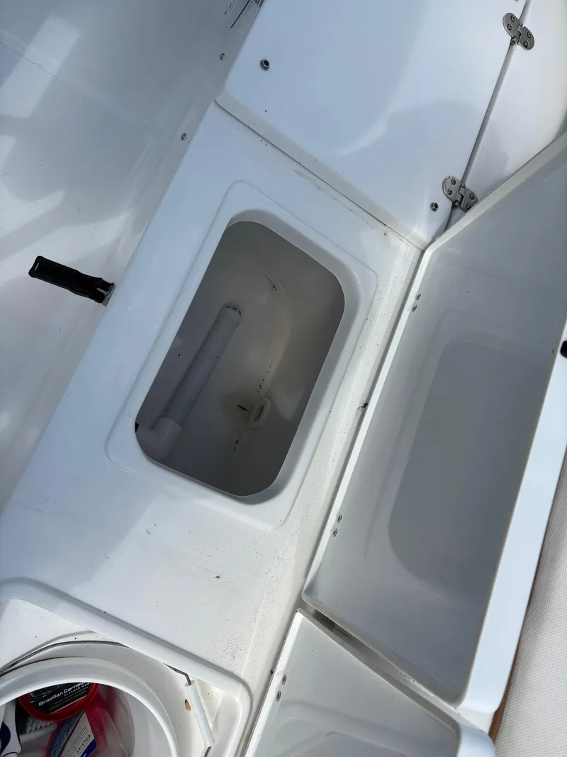 Slide: The Image of 2022 Sea Hunt Ultra 219 boat storage compartments, open and empty, showcasing interior space. - 27