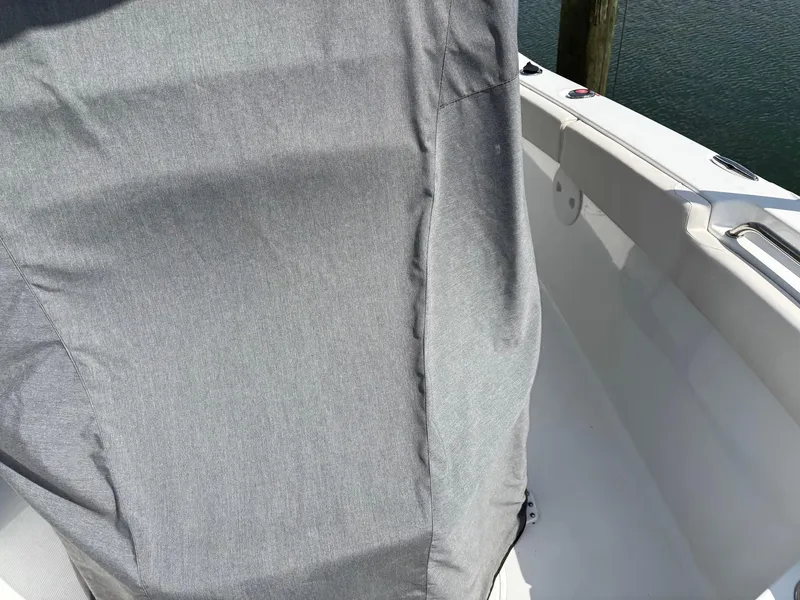 Slide: The Image of 2022 Sea Hunt Ultra 219 boat with gray seat cover, docked by water. - 32