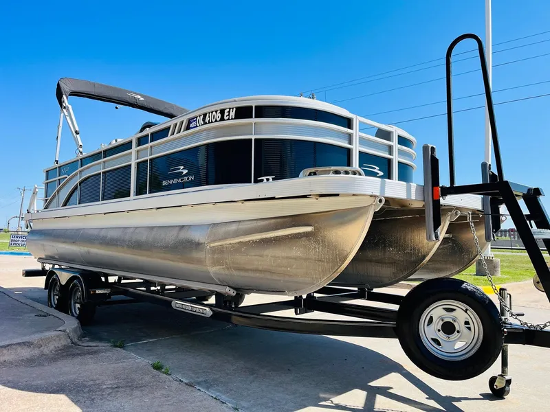 Slide: The Image of 2021 Bennington SX 22 Stern Lounge pontoon boat on a trailer, parked outdoors. - 4