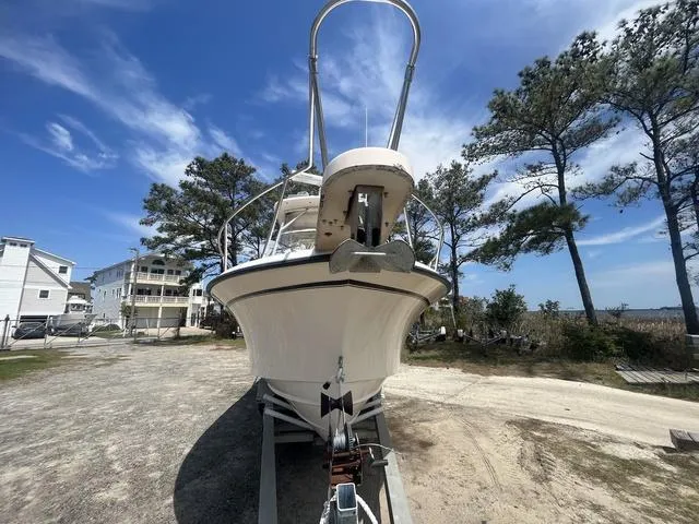 Slide: The Image of 2007 Grady-White 282 Sailfish boat on trailer, surrounded by trees and houses. - 2