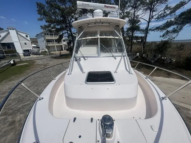 Slide: The Image of 2007 Grady-White 282 Sailfish boat docked, featuring spacious deck and cabin, surrounded by trees. - 9