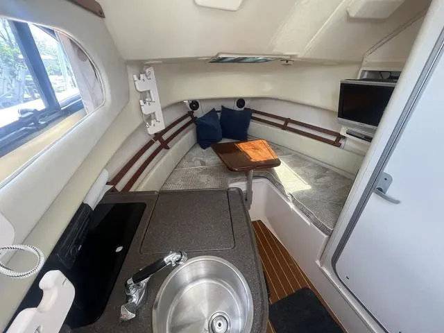 Slide: The Image of 2007 Grady-White 282 Sailfish cabin interior with kitchenette, seating, and TV. - 12