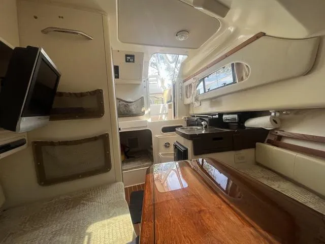 Slide: The Image of 2007 Grady-White 282 Sailfish cabin interior with kitchenette, seating, and TV. - 13