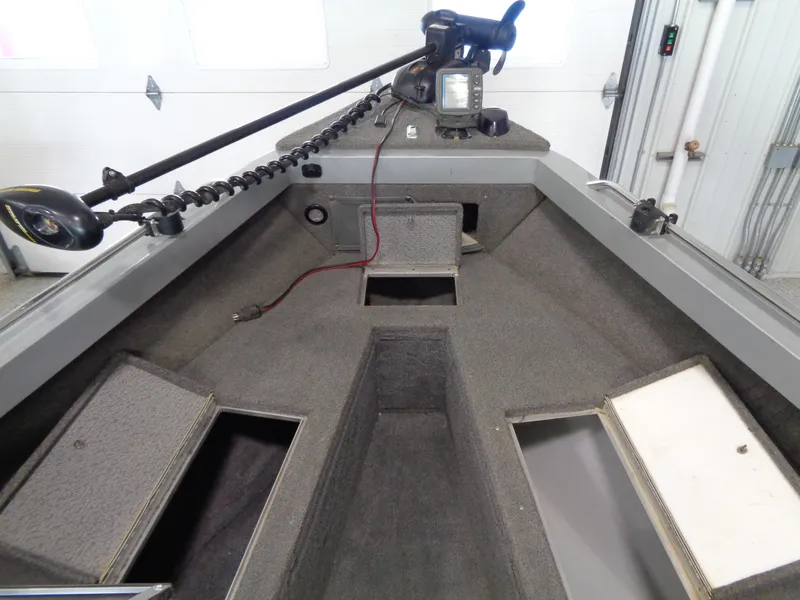 Slide: The Image of 2003 Lund 1800 Fisherman OB boat interior with storage compartments and trolling motor. - 14
