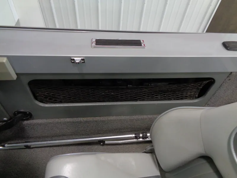 Slide: The Image of Interior view of a 2003 Lund 1800 Fisherman OB boat, featuring seating and storage. - 2