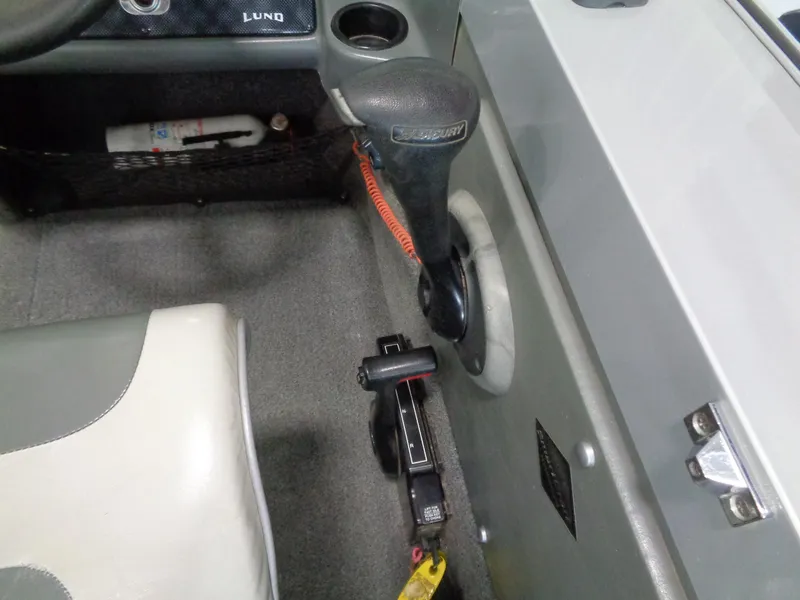 Slide: The Image of Interior of a 2003 Lund 1800 Fisherman OB boat, featuring steering controls and seating. - 20