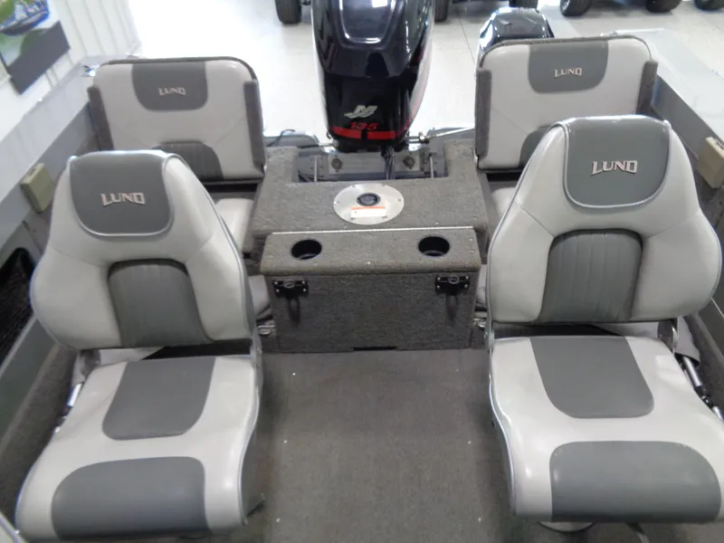 Slide: The Image of 2003 Lund 1800 Fisherman OB boat interior with four gray seats and motor. - 3