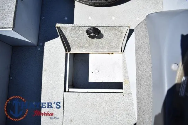 Slide: The Image of 2015 Lund 1800 Alaskan boat storage compartment with open hatch, featuring textured flooring. - 18