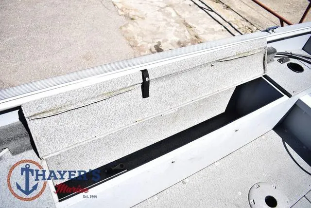 Slide: The Image of 2015 Lund 1800 Alaskan boat interior with storage compartment and Thayer's Marine logo. - 23