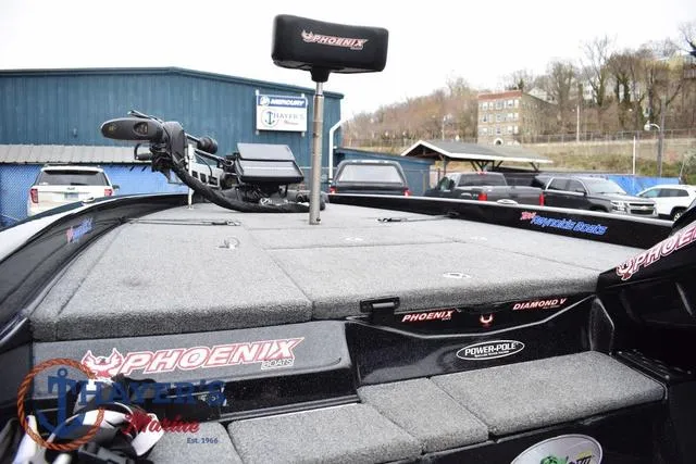 Slide: The Image of 2019 Phoenix Bass Boats 920 deck with fishing equipment and branding, parked outdoors. - 19