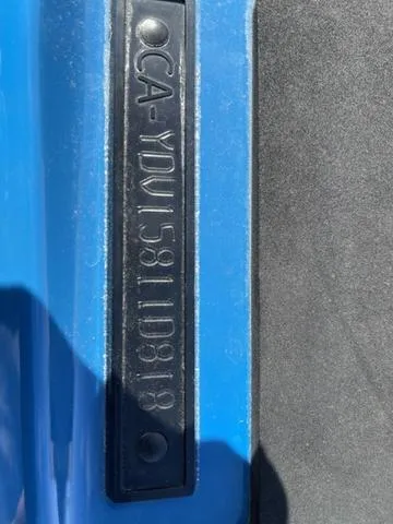 Slide: The Image of Close-up of a 2018 Sea-Doo Waverunner GTX identification plate on blue surface. - 2