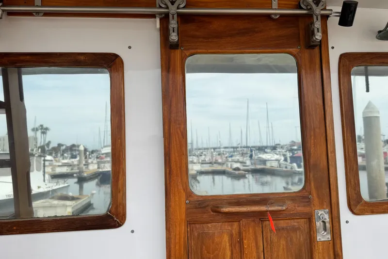 Slide: The Image of 1977 Marine Trader Europa boat interior with marina view through wooden-framed windows. - 13