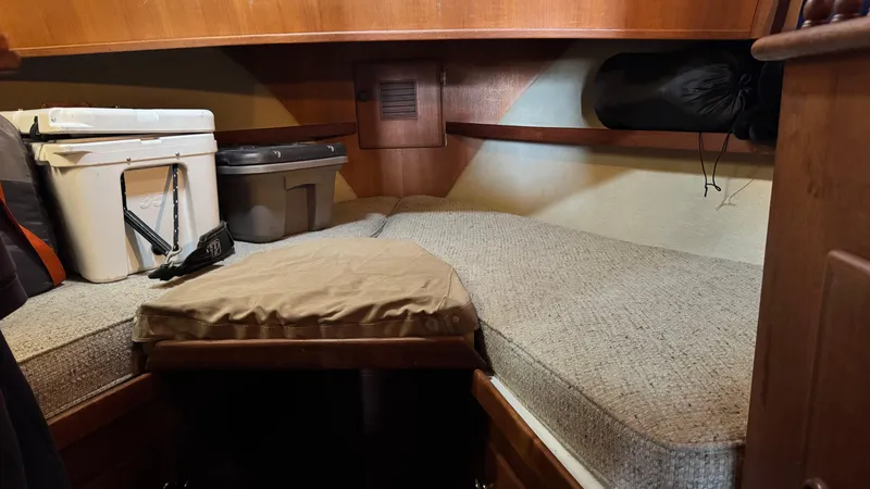 Slide: The Image of 1977 Marine Trader Europa cabin interior with storage containers and cushioned sleeping area. - 17