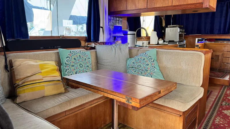Slide: The Image of Cozy 1977 Marine Trader Europa interior with cushioned seating and wooden table. - 4