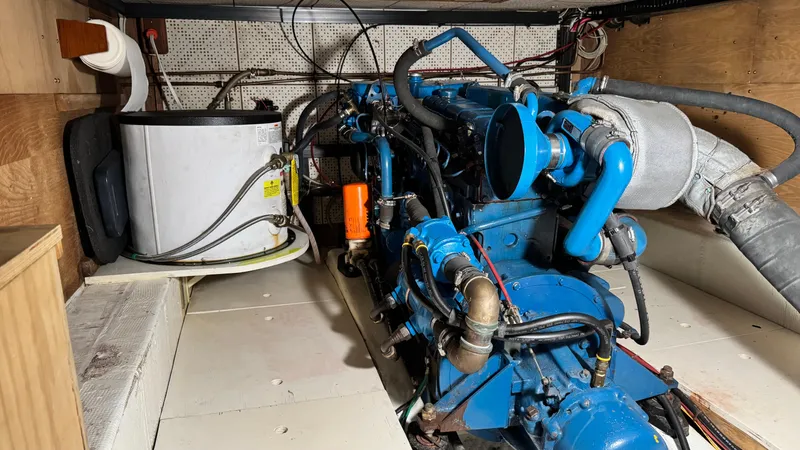 Slide: The Image of Engine room of a 1977 Marine Trader Europa boat, featuring a blue engine and components. - 9