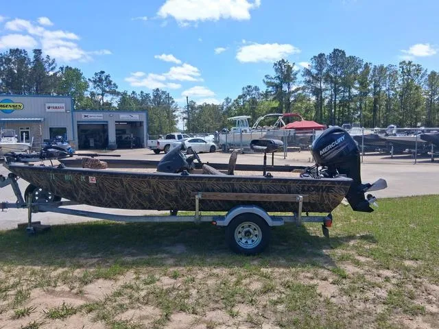 Slide: The Image of 2014 Lowe Stinger ST175 Camo boat on trailer, parked outdoors near dealership. - 2