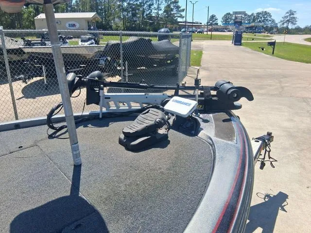 Slide: The Image of 2004 Skeeter TZX200 boat with trolling motor and fishfinder, parked near a chain-link fence. - 4