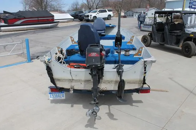 Slide: The Image of 1998 Smoker Craft BIG FISH boat with motor, parked on concrete, surrounded by vehicles. - 5