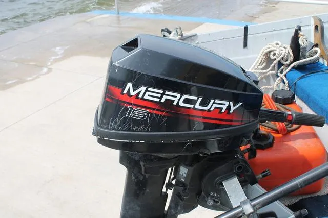 Slide: The Image of Mercury 15 outboard motor on 1998 Smoker Craft BIG FISH boat docked by water. - 6