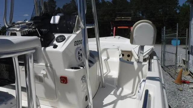 Slide: The Image of 2025 Bulls Bay 2200XS boat interior with control panel and seating, parked outdoors. - 12