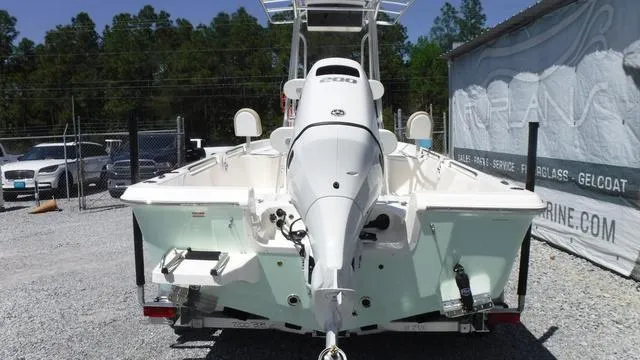 Slide: The Image of 2025 Bulls Bay 2200XS boat, rear view, parked on gravel, with outboard motor. - 2