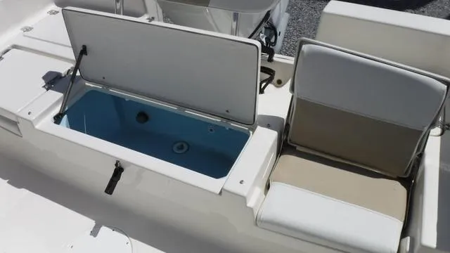 Slide: The Image of 2025 Bulls Bay 2200XS boat with open storage compartment and cushioned seating. - 9
